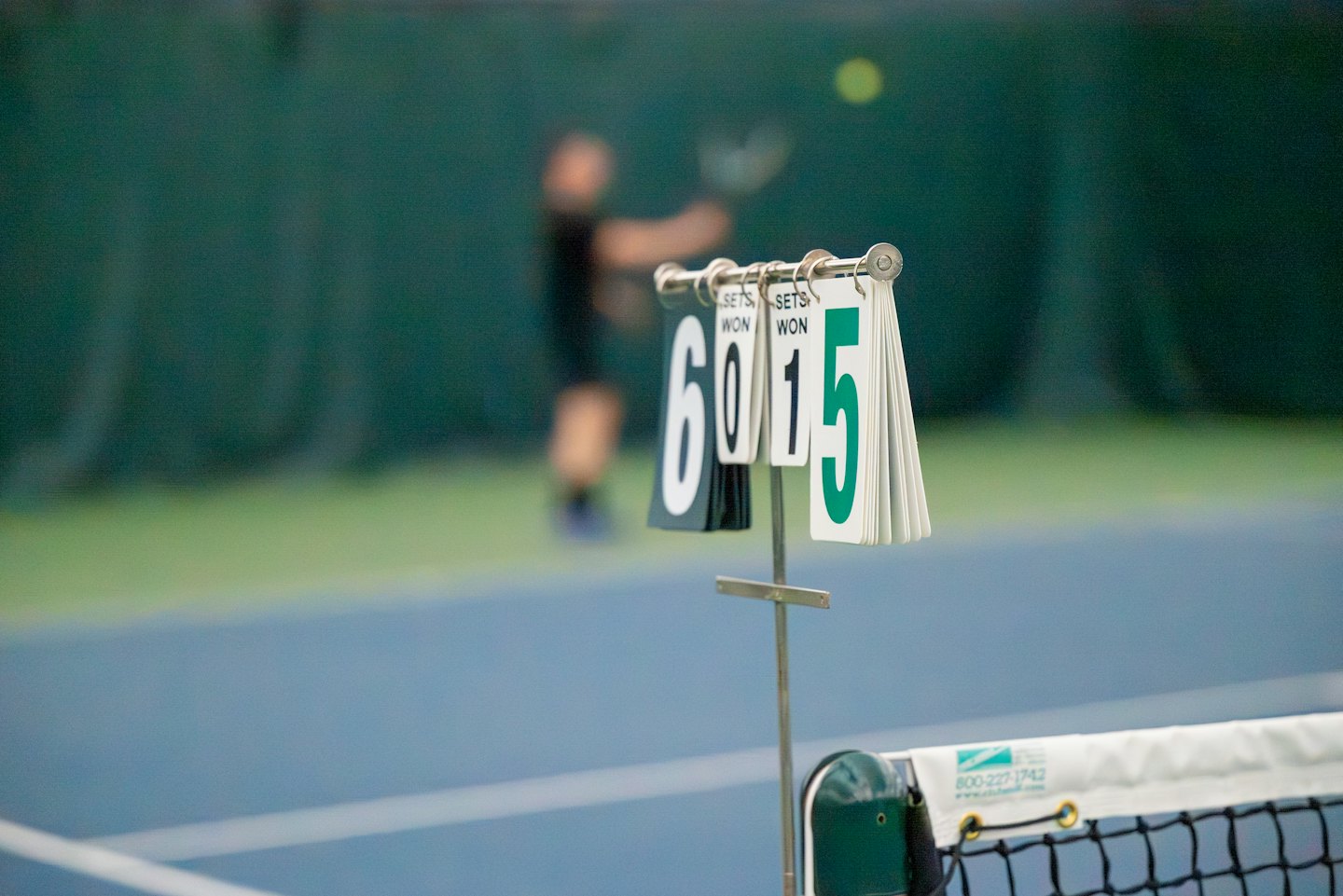 Marcador de tenis mostrando el resultado durante un partido en interiores.